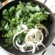 Kale and onion are added to the pan of pork juices and seasoned
