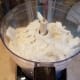 Then I pull my coconut oil out of the freezer and break it all into small pieces. I add that to my processor and process that in as well.