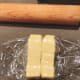 Loosely wrap the butter with plastic wrap and press it down with a rolling pin to form a thin sheet of butter.
