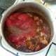Tomatoes and seasonings are added to curried chicken