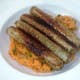vegan sausages are served on the mashed sweet potato bed