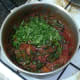 Chopped coriander is added to chicken and spinach curry