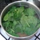 Spinach is added to simmering pasta