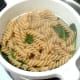 Drained pasta and spinach is left to steam