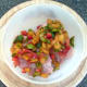 Diced bell peppers are arranged on skinned chicken thighs