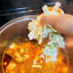 After 5 minutes, add the cabbage, tomato, young corn, bell pepper, mushroom, and onion.