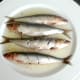 Slashed sardines are turned in garlic oil