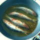 Frying paprika spiced sardines in olive oil