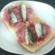 Sardines are arranged on top of bacon