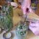 Put into each quart jar: 2 cloves of garlic, 2 heads of dill (about 1 teaspoon of seeds), 1/2 teaspoon cayenne pepper. For each pint, that's: 1 clove garlic, 1/2 teaspoon dill seeds, 1/4 teaspoon cayenne.