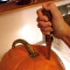 Begin by cutting a slit in the pumpkin near the stem. You may have to stab hard. Make sure your knife is very sharp.
