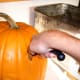 ...then switch to a serrated knife and cut to the bottom center of the pumpkin. Repeat at a different angle...
