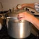Screw or fasten lid in place. On old-style canners, screw knobs down tightly in opposites, to achieve an even seal.