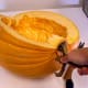 The more wedges you cut, the harder it may be to hold your pumpkin still. Engage another pair of hands if necessary. Scrape seeds into a waiting bowl as you complete each slice, but don't bother yet with "strings".