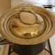 Closeup of lidded stainless bowl in a sauce pan.