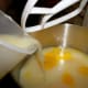 Adding lemon juice to sweetened condensed milk and egg yolks.