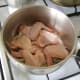 The chicken wings are laid on top of the sliced onion, salt and peppercorns