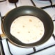 The tortilla wraps are heated in a dry frying pan