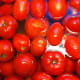 Tomatoes in sink covered with boiled water so peelings will slide off.