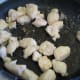 2.Stir fry chicken. Heat up the skillet to medium. Put chicken in the pan. Sprinkle on garlic salt and ginger. Stir and fry until no longer pink inside, about 7 minutes.
