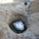 Before lowering your bird into your pit, shovel a layer of hot charcoal on top of the rocks at the bottom of your pit.