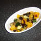 Roasted vegetables are laid in the base of a serving dish