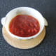 The hot tomato sauce is poured carefully over the sardines