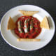Fresh sardines cooked in homemade tomato sauce are served with hot, buttered toast.
