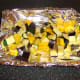 Vegetables are spread in a single layer on a foil lined baking tray