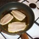 The sardines are added to the pan skin side down