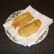 Deep fried whiting is drained on kitchen paper