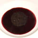 Black pudding is laid on the red wine and cranberry reduction
