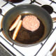 Burger and sausages are gently fried