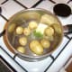Butter and chopped mint are added to drained potatoes