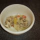 The solids are removed from the lamb stock with a slotted spoon and discarded