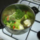 Herbs and peppercorns are added to the sautéed vegetables.