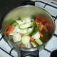 Vegetables are added to the stock pot and warmed olive oil.