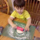 Rolling out the biscuits with a rolling pin.
