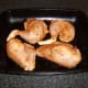 Chicken is arranged on a lightly oiled roasting tray