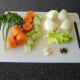 Vegetables and herbs are prepared for poaching chicken