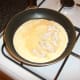 Chicken is added to half the almost set omelette