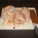 Leg portions and thighs are removed from chicken and main body halved through the breastbone