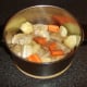 Vegetables, herbs and seasonings are added to the stew pot