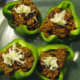 Top the stuffed peppers with shredded cheese.