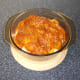 Jalfrezi sauce is poured over the chicken thighs and onion