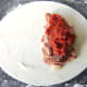 Spoon the tomato sauce on top of the sausage and bacon