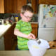 Nolan measured and added the lemon juice to the ingredients in the mixing bowl.