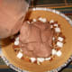 Pour the ice cream into the pie shell. Spread evenly with the back of a spoon.