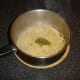 Green pesto sauce is stirred through drained spaghetti