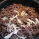 Brown the meat and add the onions and taco sauce.